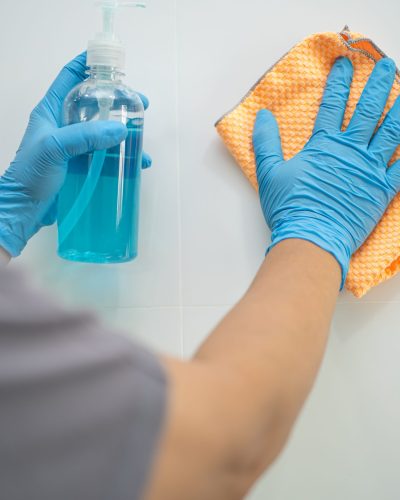 Cleaning tile wall with cloth and alcohol in kitchen at home for protect covid 19 coronavirus